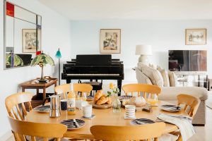 Living area with grand piano and dining area at Bodeeve in Praa Sands